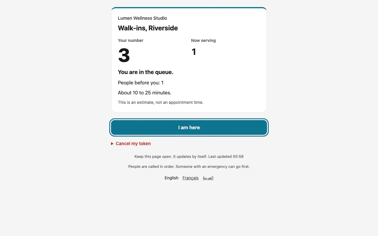 The token page on a phone-sized screen with "Your number", "Now serving" and the "I am here" button outlined